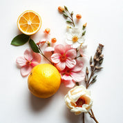 Orange blossom and peony flowers surrounded by oranges representing the olfactory notes of the perfume.