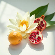 A hibiscus, pomegranate and mandarin representing the olfactory notes of the perfume.