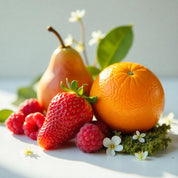 A pear, an orange, a strawberry and raspberries on moss representing the olfactory notes of the perfume.