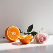 Mandarin and rose representing the olfactory notes of the perfume.